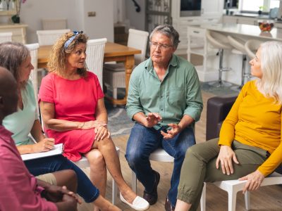 Multiracial senior men and women discussing during group therapy session