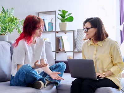 Therapy session for teenage girl, psychologist and patient together in office